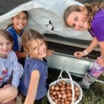 kids looking back while picking eggs
